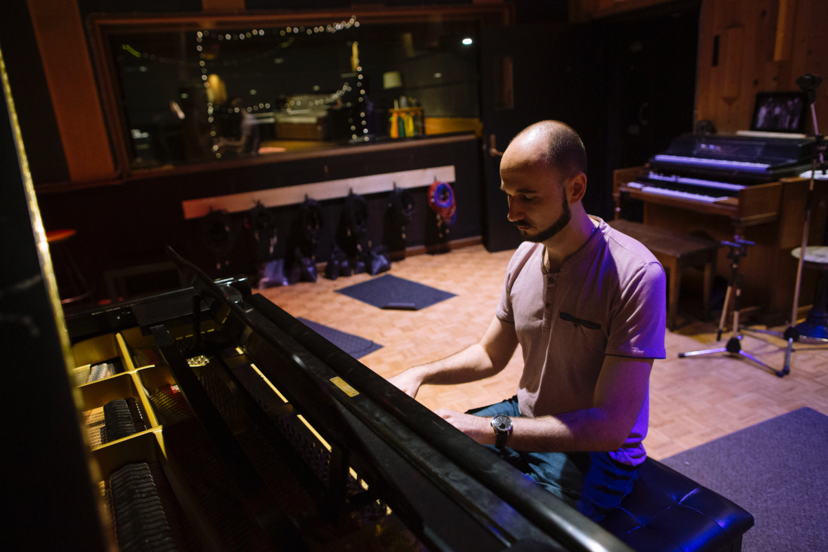 Pianist Dmitri Kristalinsky playing piano in a recording studio environment